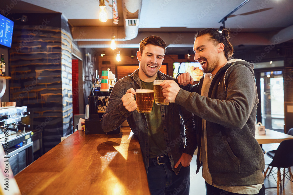 Friends talk, drink beer in a bar.