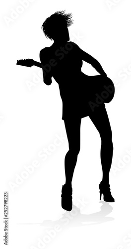 A female guitarist musician in detailed silhouette playing her guitar musical instrument.