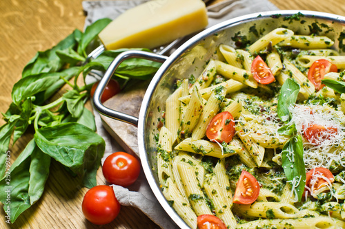 Penne pasta with spinach, cherry tomatoes and Basil. Wooden background, side view