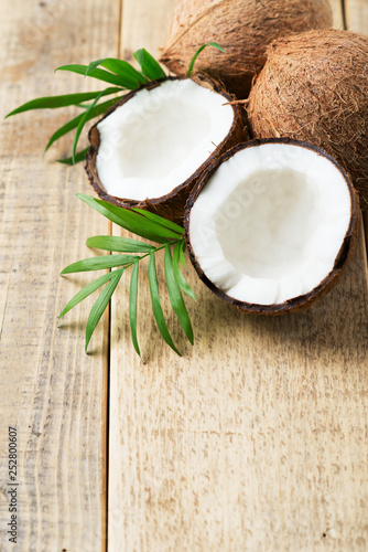 Fresh coconut with leaves on wooden background