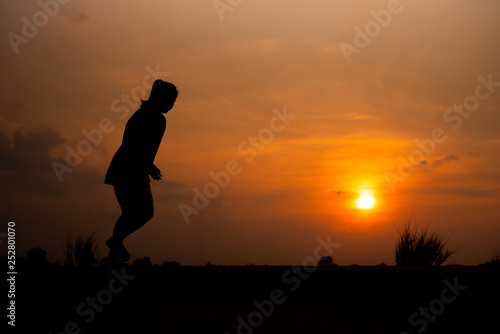 young fitness woman running on sunset seaside trail - Image © patcharee11