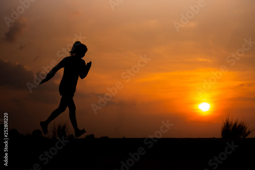 young fitness woman running on sunset seaside trail - Image © patcharee11