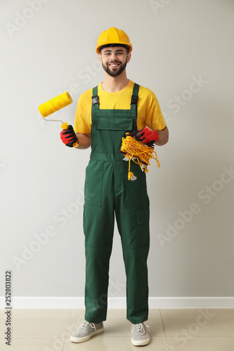 Worker with paint roller ne...