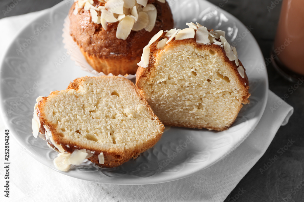 Plate with tasty almond muffins on table