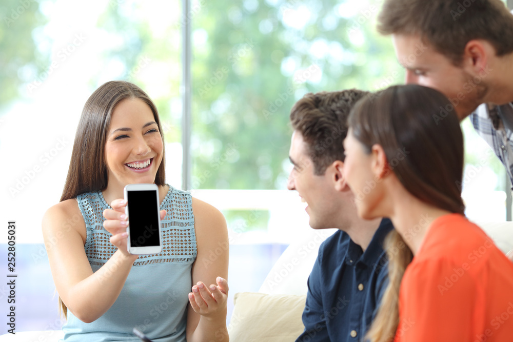 Woman showing blank phone screen to her friends Woman showing blank phone screen to her friends