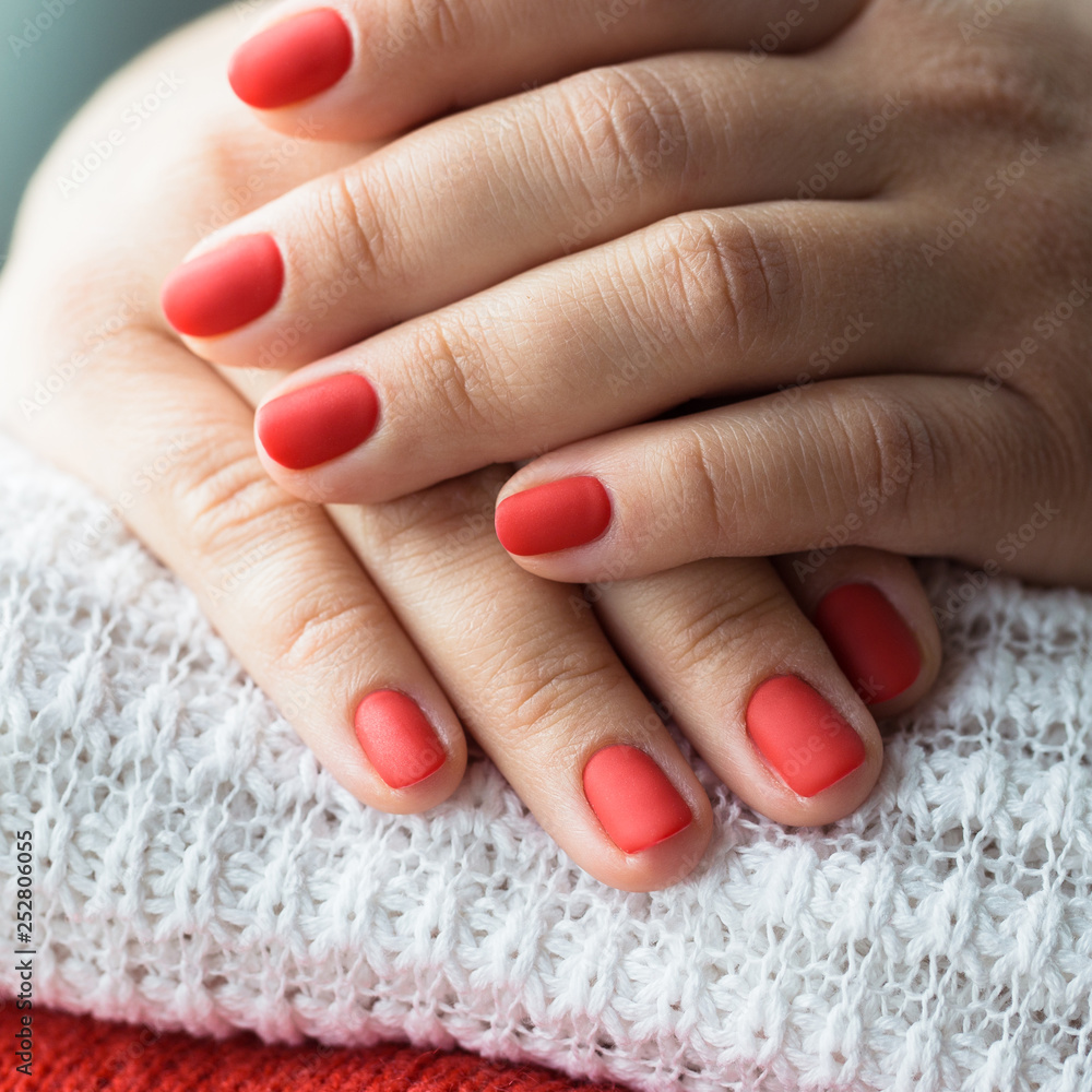 Closeup photo of a beautiful female hands with red nails Closeup photo of a beautiful female hands with red nails