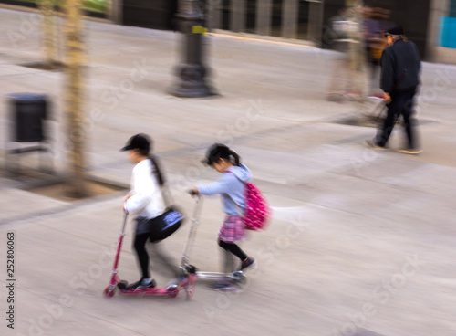 Little girsl riding scooter outdoors photo