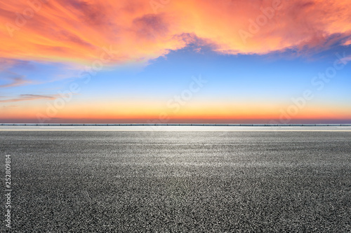 Empty asphalt road and beautiful colorful clouds at sunset © ABCDstock