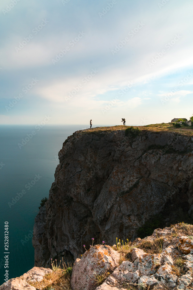 photographer and model on the edge of a cliff
