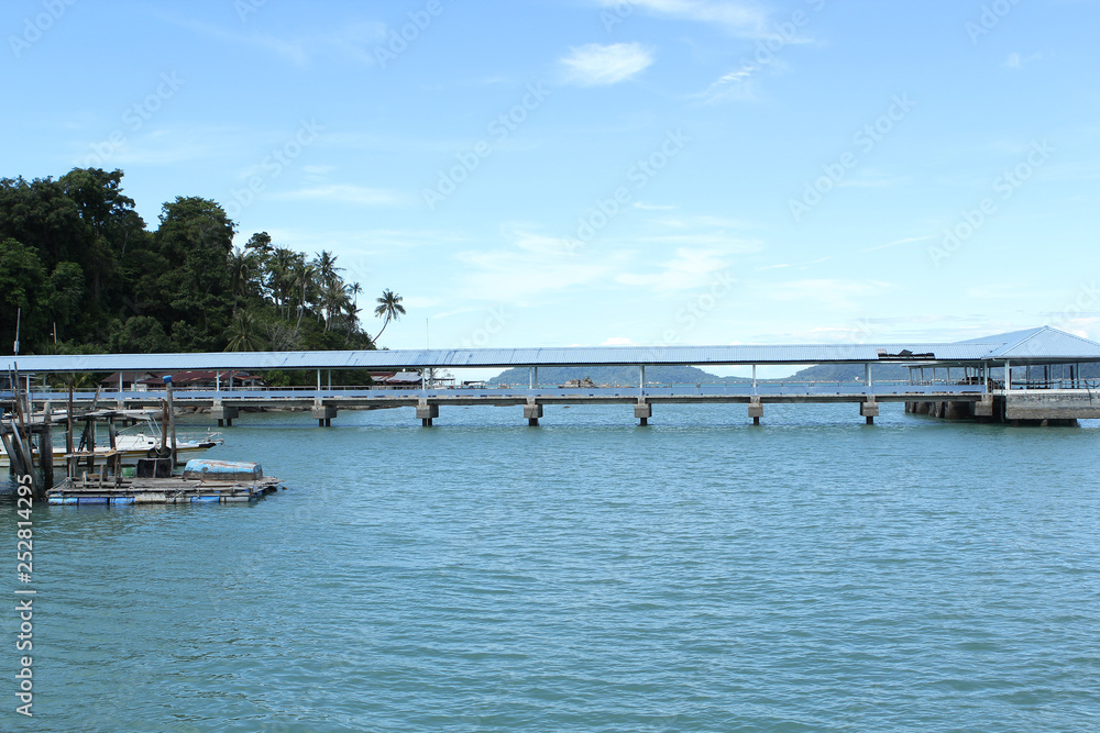 Romantic seascape in a beautiful bay, wooden jetty, Malaysia, island, Malacca Strait, concept of vacation, travel.