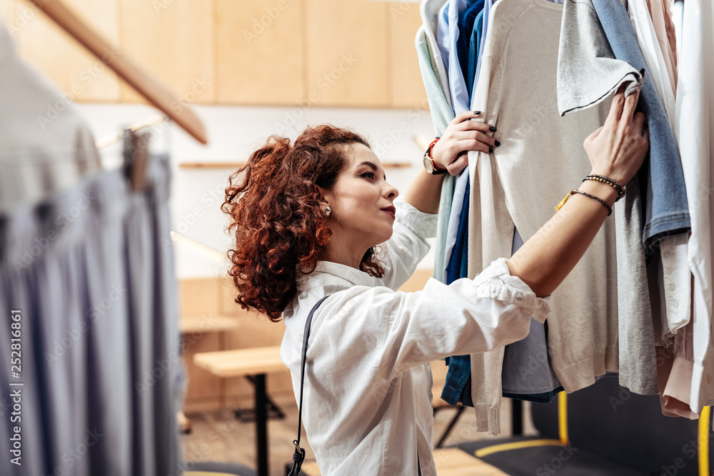 Young curly dark-haired wife choosing present for her husband Young curly dark-haired wife choosing present for her husband
