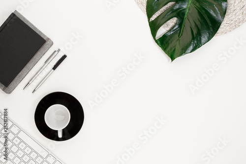 coffee cab pen notepad kayboard  office leaf monstera top view with copy space for your text. flat lay.  photo