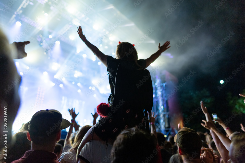 Crowd enjoying in live concert at music festival by night.
