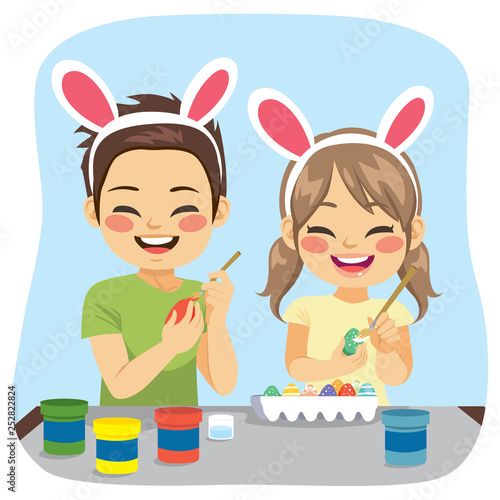 Young cute siblings painting decorated Easter eggs funny creative activity