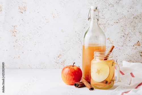 Cool, healthy drink with apple cider vinegar, honey, apples and cinnamon photo