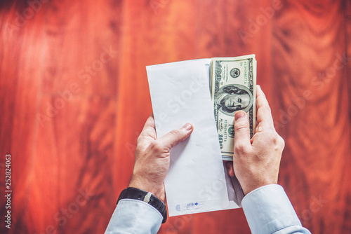 Closeup of man hands count us dollar money, male hand putting money in empty white envelope