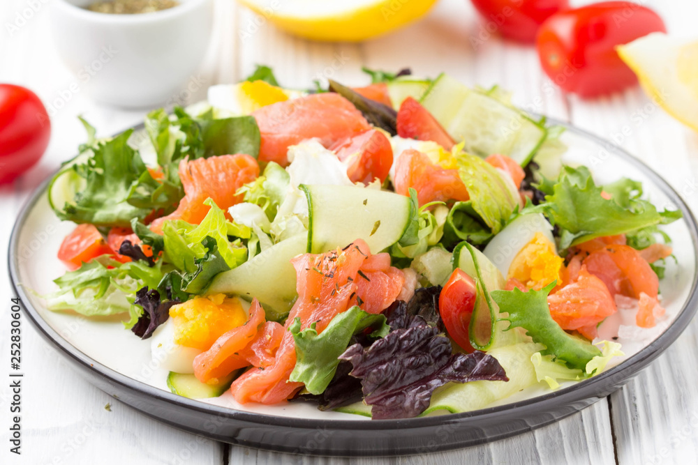 Salad with salmon, egg and vegetables (cherry tomatoes, cucumber, lettuce), delicious light lunch, healthy food Salad with salmon, egg and vegetables (cherry tomatoes, cucumber, lettuce), delicious light lunch, healthy food
