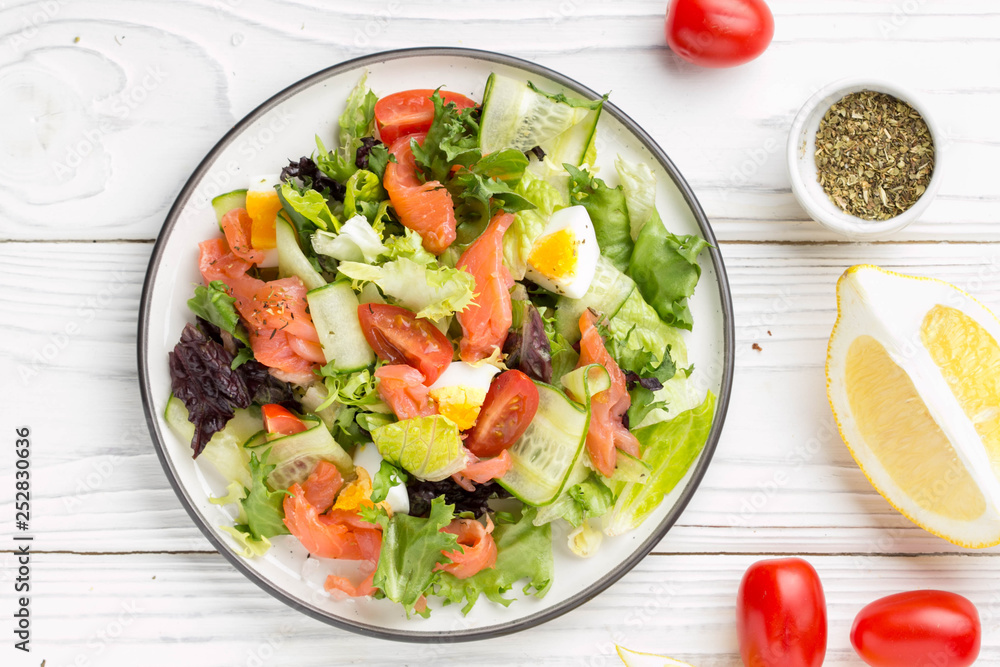 Salad with salmon, egg and vegetables (cherry tomatoes, cucumber, lettuce), delicious light lunch, healthy food Salad with salmon, egg and vegetables (cherry tomatoes, cucumber, lettuce), delicious light lunch, healthy food