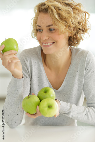 smiling young woman holding apple