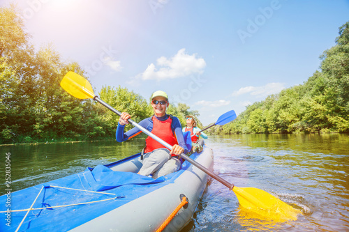 Happy family kayaking on the river on a sunny day during summer vacation
