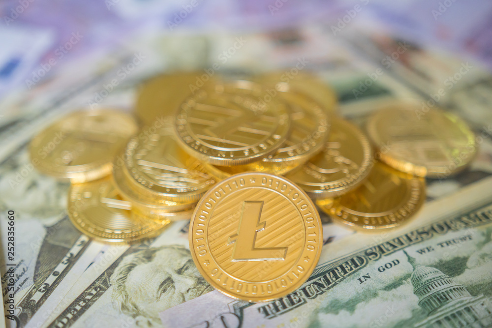 Business concept of crypto currency. Golden Lightcoin on us dollars close up. Business concept of crypto currency. Golden Lightcoin on us dollars close up.