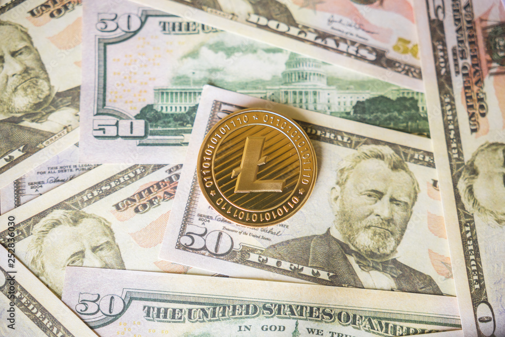 Lightcoin cryptocurrency coin on us dollars close up. Lightcoin cryptocurrency coin on us dollars close up.