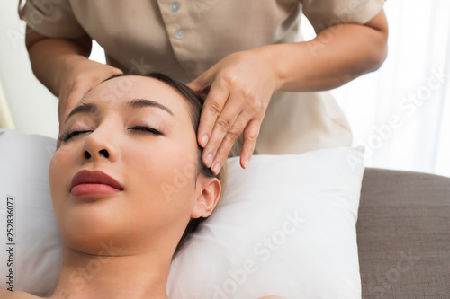 Ayurvedic Head Massage Therapy on facial forehead Master Chakra Point of Mix Race Caucasian Asian woman  Therapist Spa body woman hands treatment on customer to increase circulation release tension