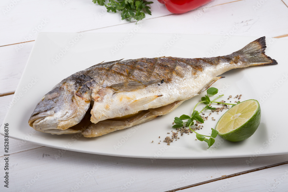 Grilled dorado fish served on a white plate Grilled dorado fish served on a white plate