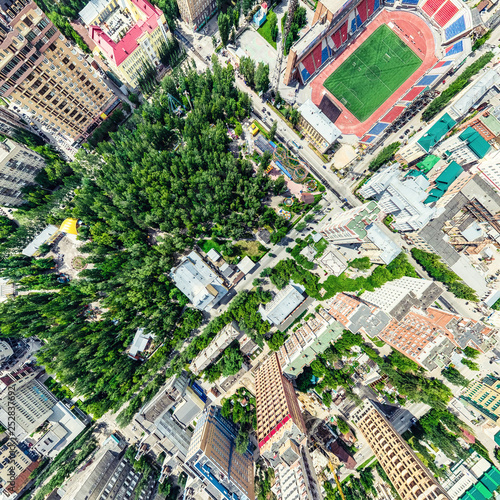 Aerial city view with crossroads and roads  houses  buildings  parks and parking lots. Sunny summer panoramic image