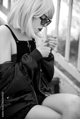 Attractive young woman with bob hair lightning a cigarette