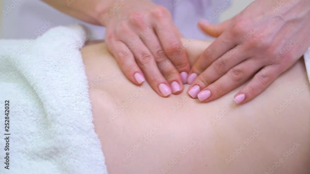 closeup of female hands doing anti cellulite massage on abdomen of young woman closeup of female hands doing anti cellulite massage on abdomen of young woman