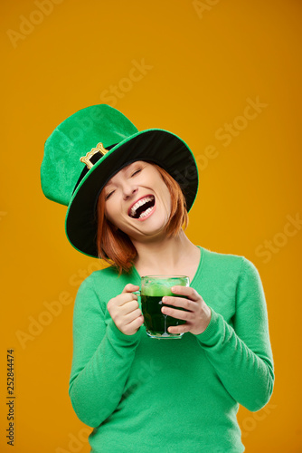 Happy woman with leprechaun's hat drinking beer © gpointstudio