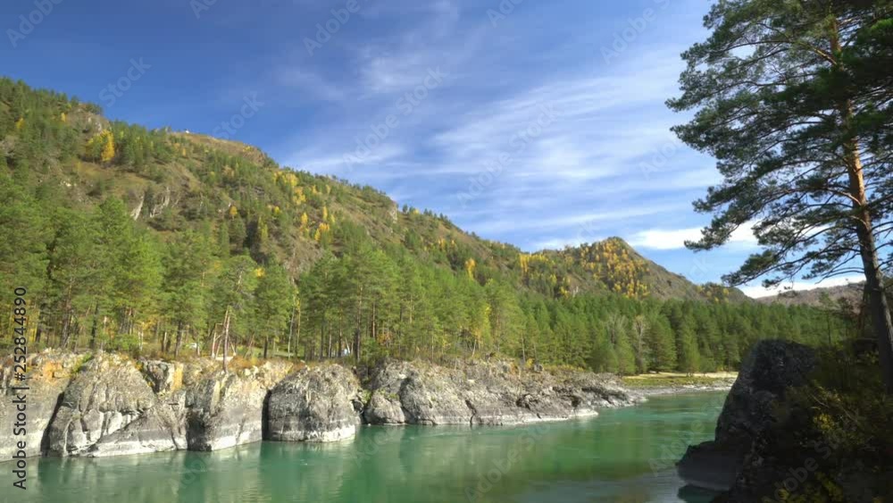 Two videos in one.Altai. Mountain lake. Fall. The woman the traveler in tourist boots goes on the coast of the lake. Close up. Beautiful look. Two videos in one.Altai. Mountain lake. Fall. The woman the traveler in tourist boots goes on the coast of the lake. Close up. Beautiful look.