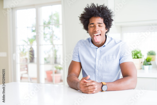African American business man sticking tongue out happy with funny expression. Emotion concept.