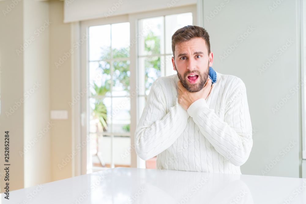 Handsome man wearing casual sweater shouting and suffocate because painful strangle. Health problem. Asphyxiate and suicide concept.