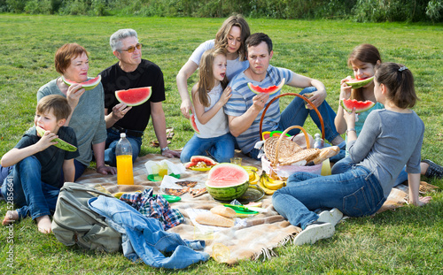Happy people sitting and talking on picnic