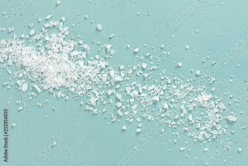 Coarse sea salt on the blue textured table photo