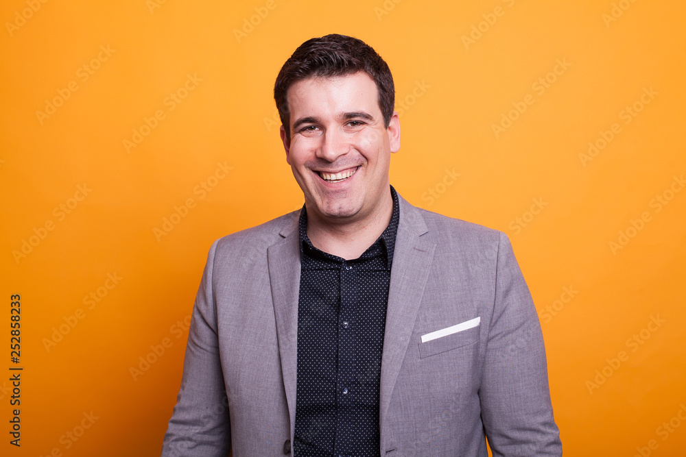 Portrait of young man smiling over yellow background Portrait of young man smiling over yellow background