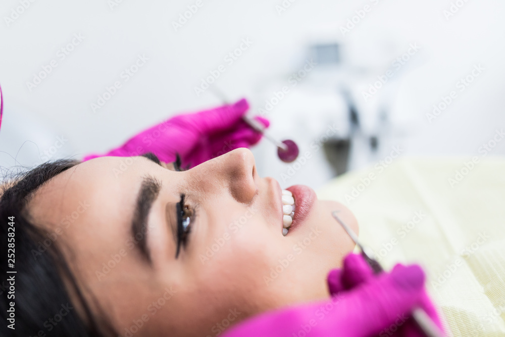 Fototapeta premium Young woman having dental check-up in dentist office, smiling.