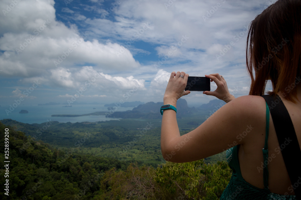 A girl takes pictures of a beautiful view the Andaman Sea