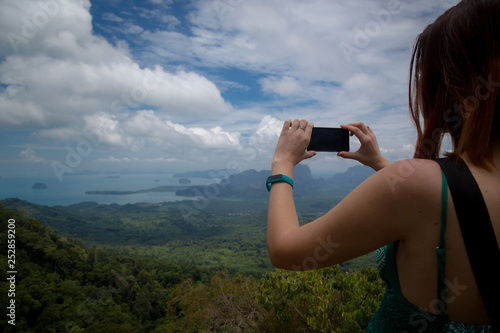 A girl takes pictures of a beautiful view the Andaman Sea