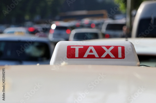 Taxi light sign or cab sign in white and red color with white text on the car roof