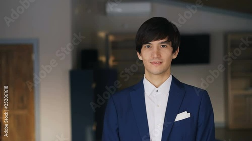 Wallpaper Mural Portrait of dark-haired handsome young man in blue suit and white shirt smiling and looking at camera. Young people, beautiful interior and happiness concept. Torontodigital.ca