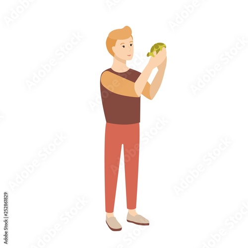 Funny young man or teenage boy holding tortoise or turtle