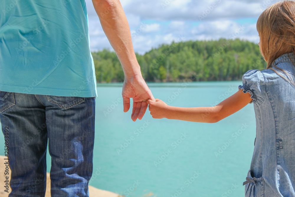 parent holds the hand of a small child parent holds the hand of a small child