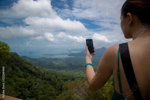 A girl takes pictures of a beautiful view the Andaman Sea