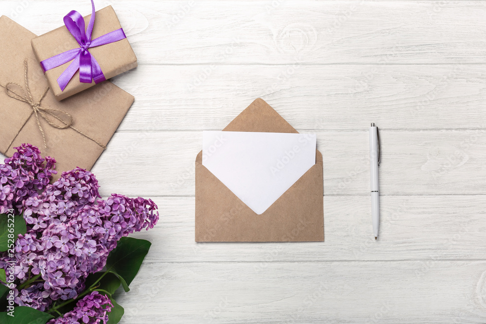 A bouquet of lilacs with craft envelope, gift box, a love note on white boards A bouquet of lilacs with craft envelope, gift box, a love note on white boards