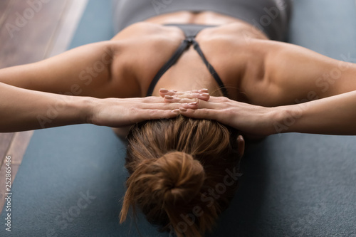 Woman practicing yoga, doing neck strengthening exercises on mat photo