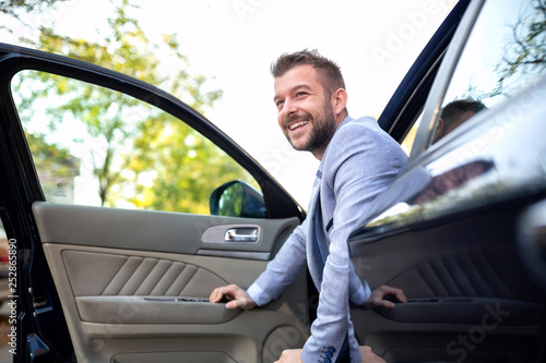 Принти на полотні Smiling man exiting his vehicle