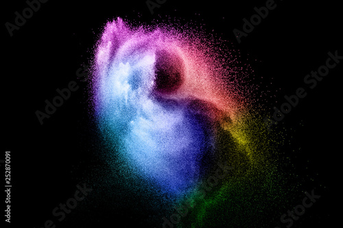 Abstract multi color powder explosion on black background. Freeze motion of colorful dust particles splash. Painted Holi.
